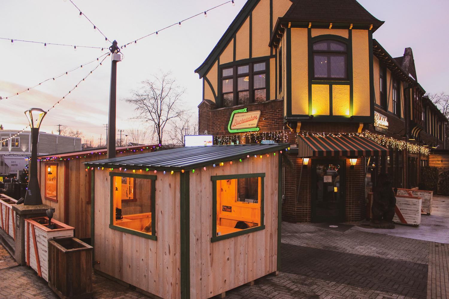 The exterior of Buckatabon Tavern & Supper Club featuring the outdoor shanties at sunset